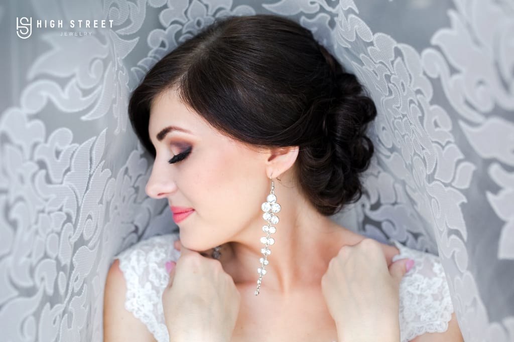 Image showing a bride to be in white, wearing dangling leaf-shaped earrings